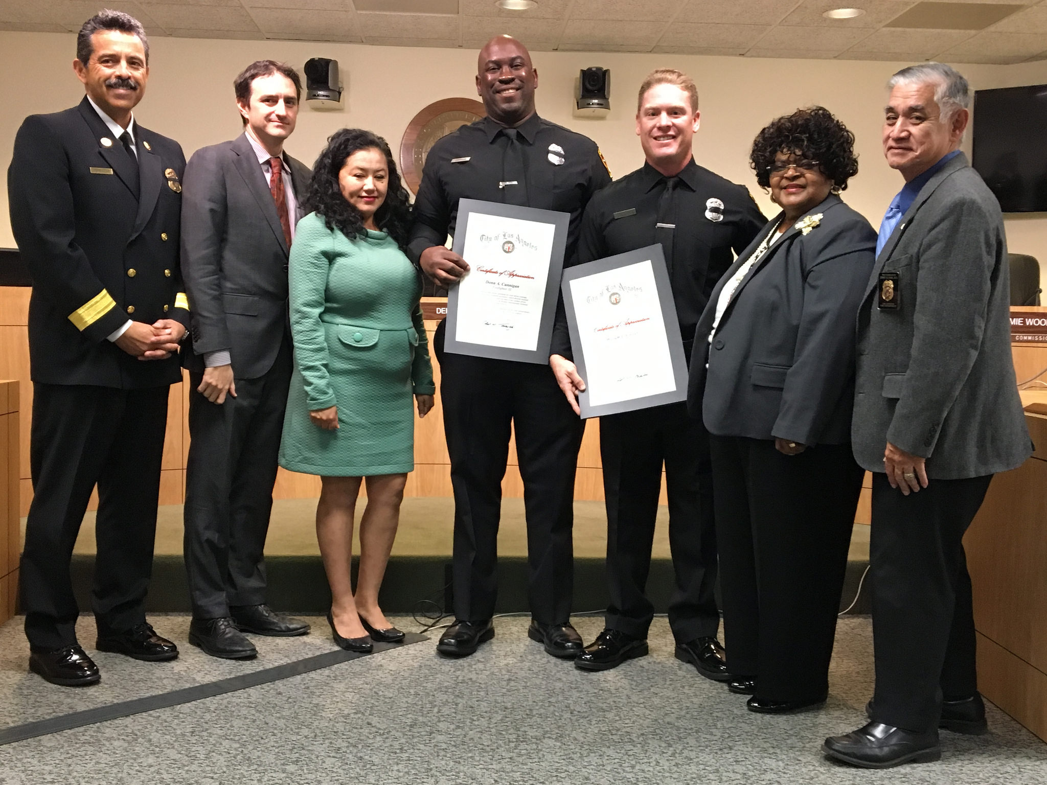 Image of two firefighter awardees standing with Fire Chief and members of the Board of Fire Commissioners