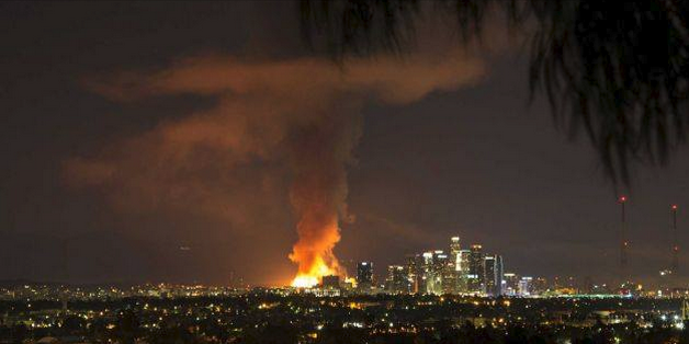 Distant view of Los Angeles skyline with very large fire visible.