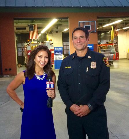 LAFD Battalion Chief in front of Station 64 with news reporter.