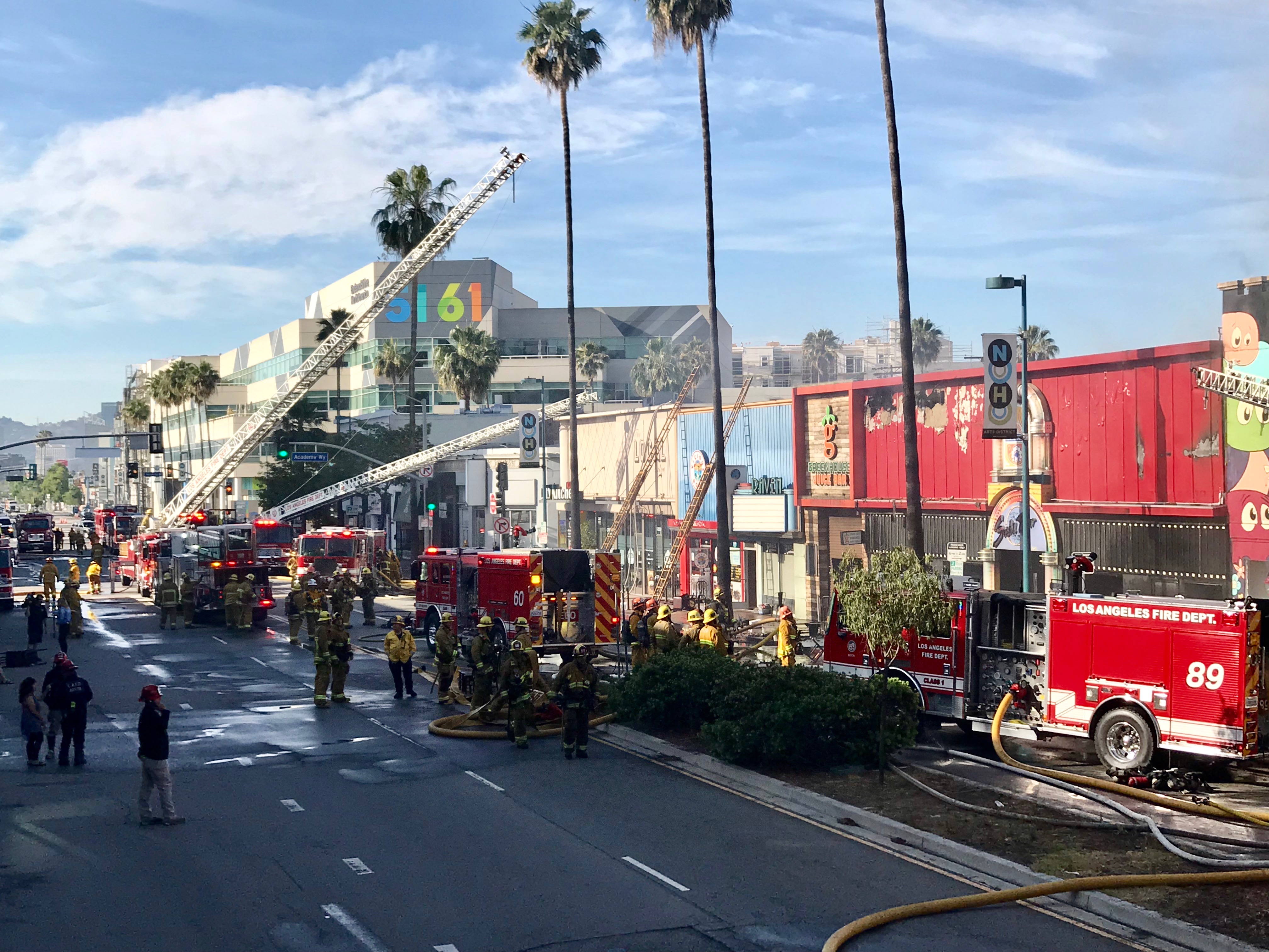 Numerous fire engines and firefighters outside building working