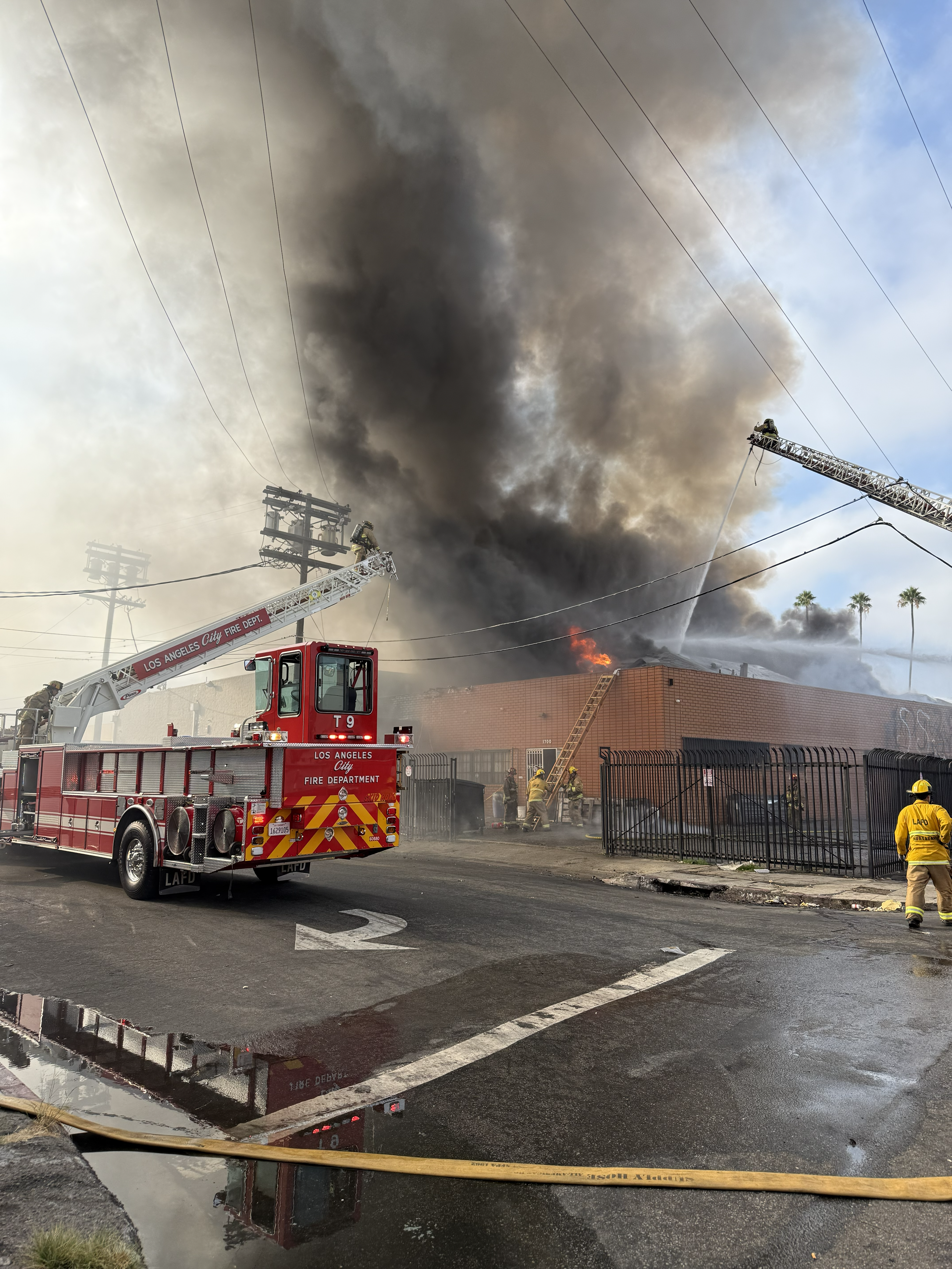 Firefighters on aerial ladders putting water on the fire.