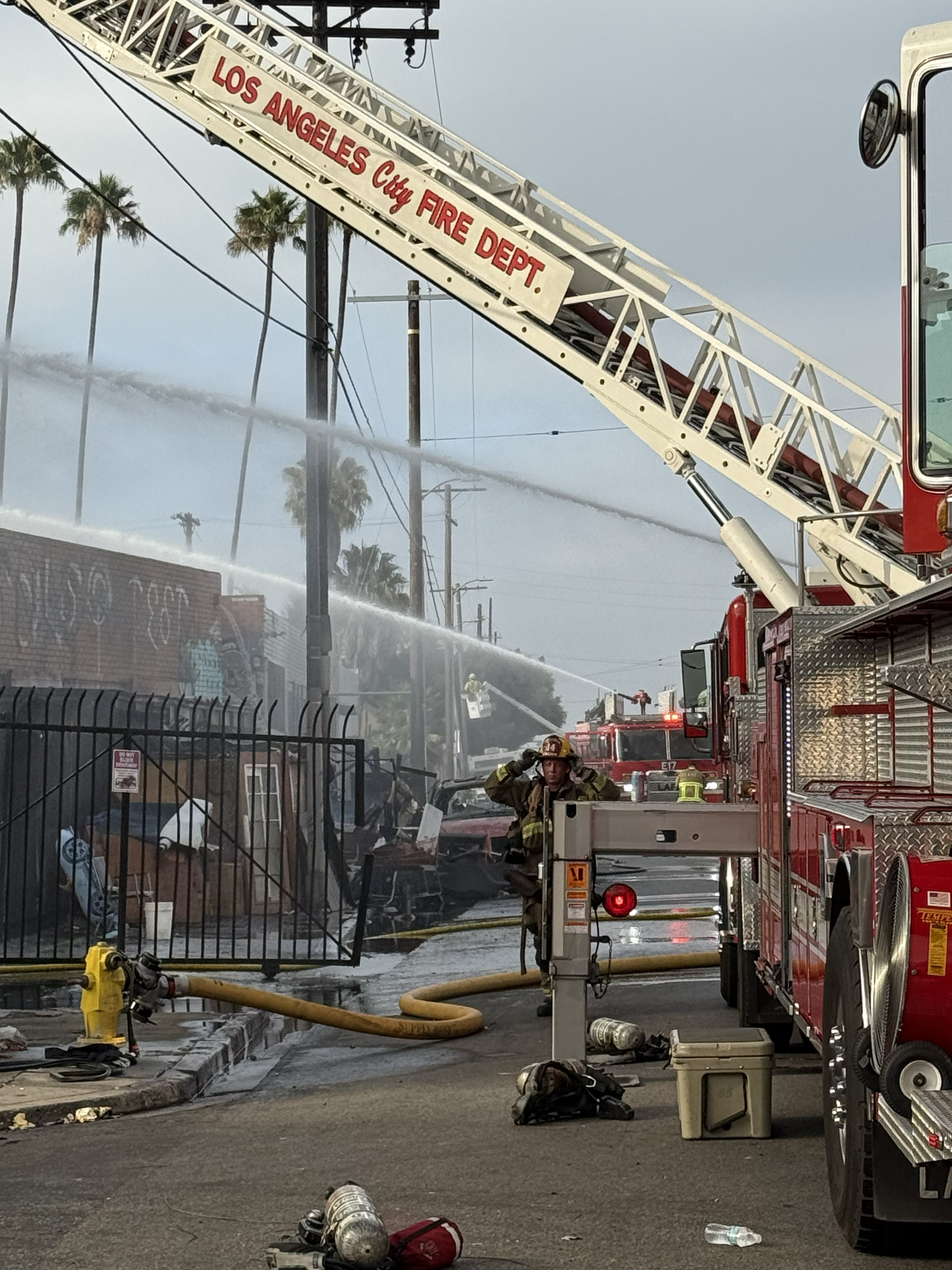 Aerial ladders from the Los Angeles Fire Department and Department of Water and Power in the back ground. DWP has handling turning the power off from the building.