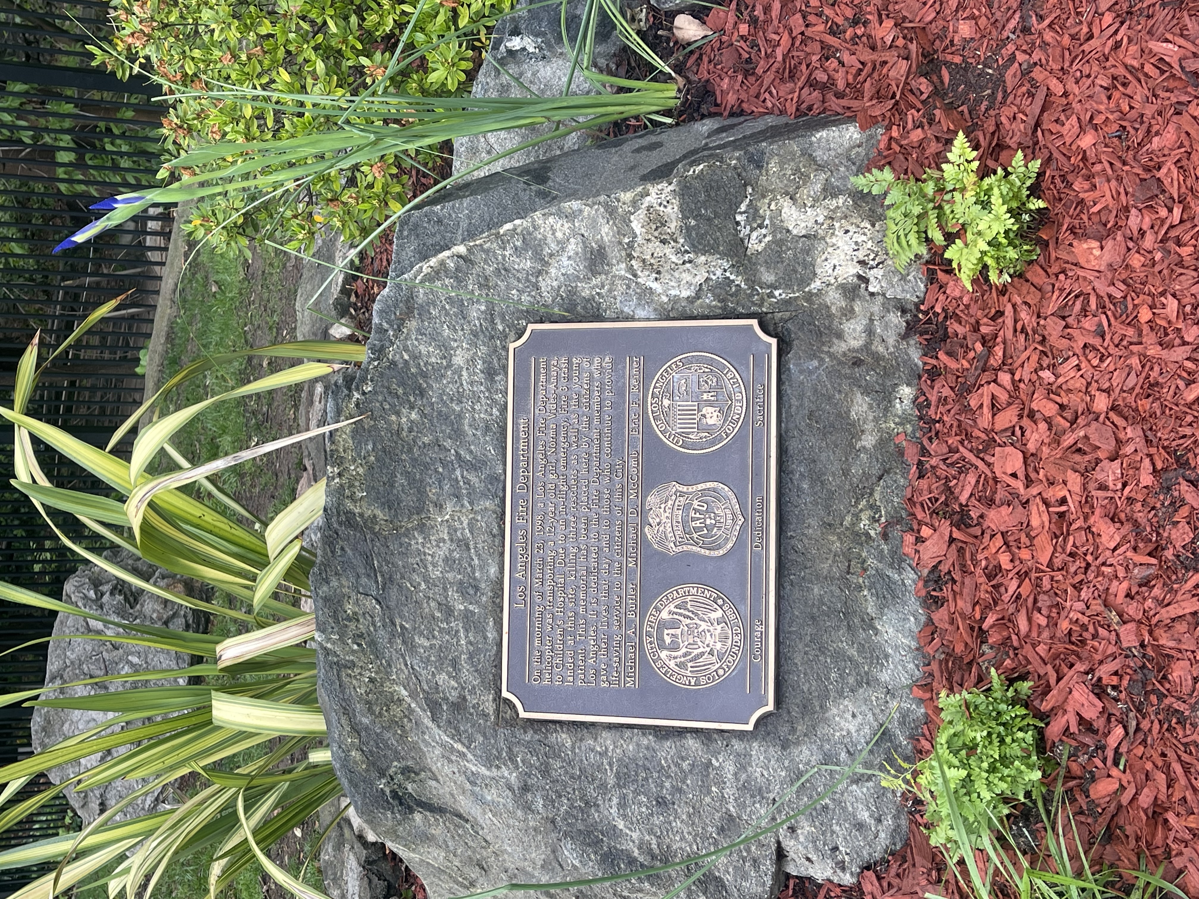 Plaque honoring those who died show in the landscaped area