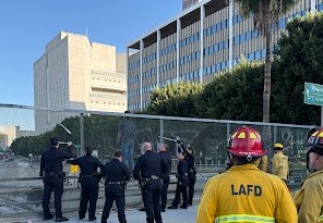 LAPD using pry bars to restrict the movement and keep the man threatening to jump above the rescue air cushions.