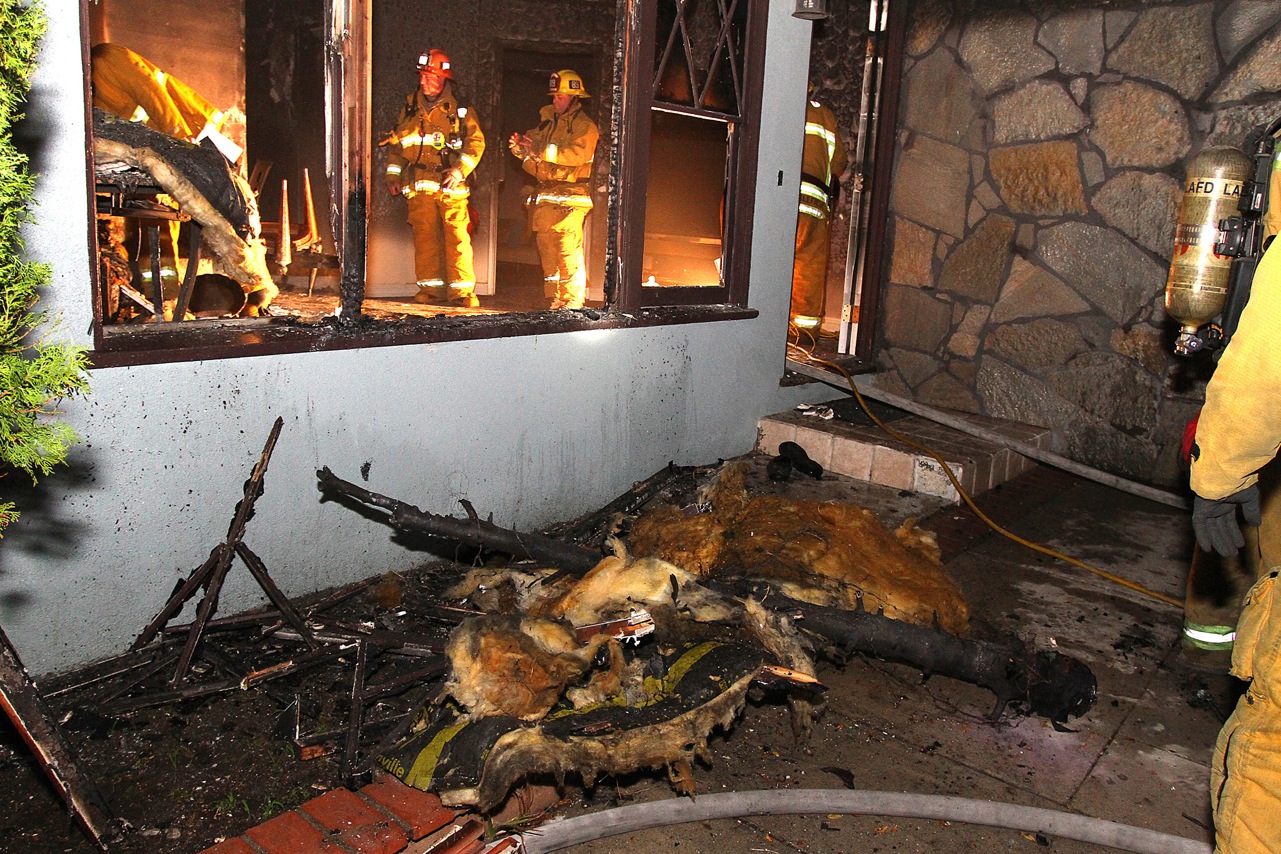 home destroyed by fire with burnt christmas tree visible in the front