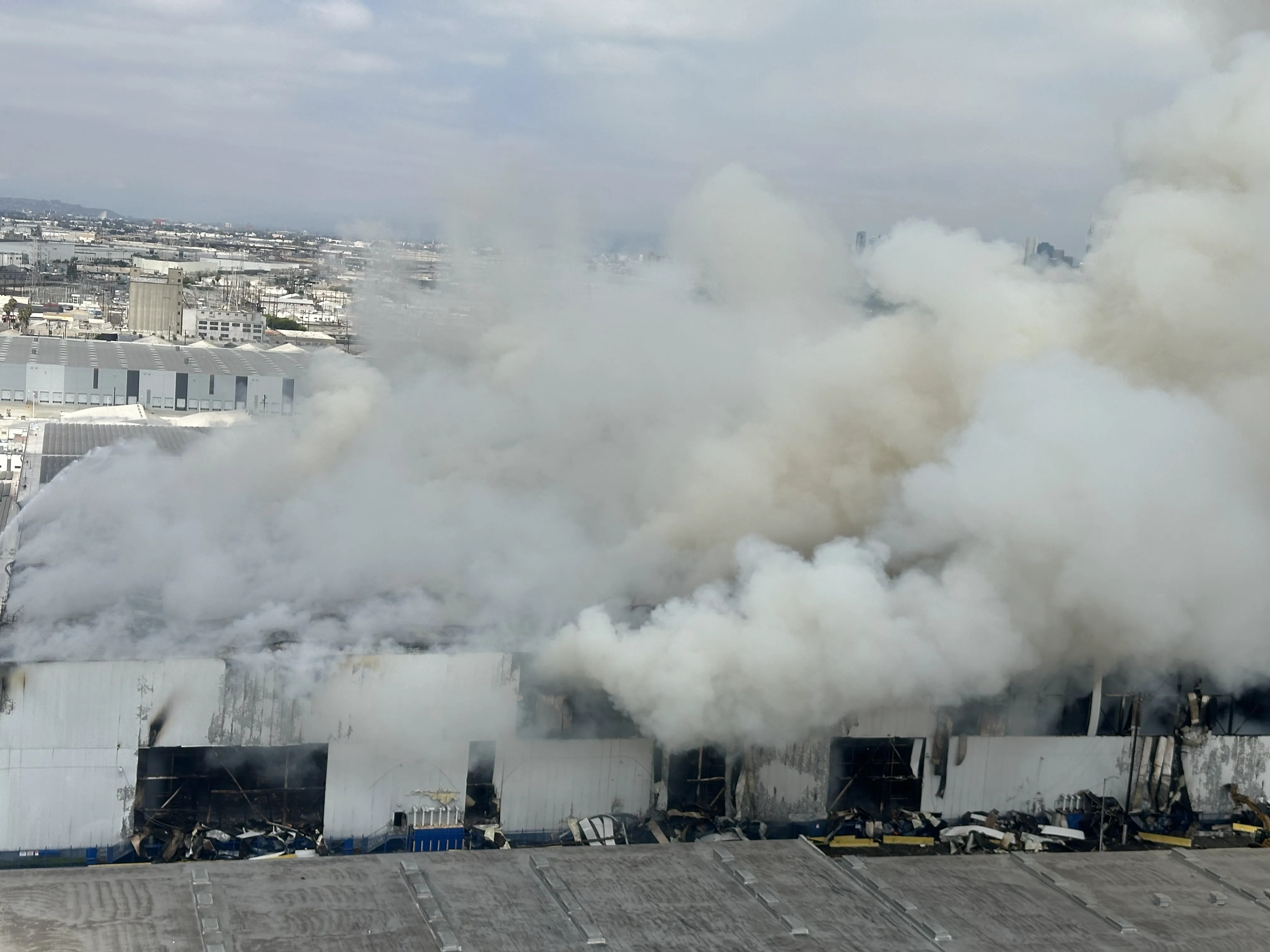 Photo of warehouse on fire with heavy smoke